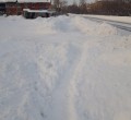 Тротуар вдоль дома завален снегом
