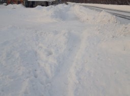 Тротуар вдоль дома завален снегом